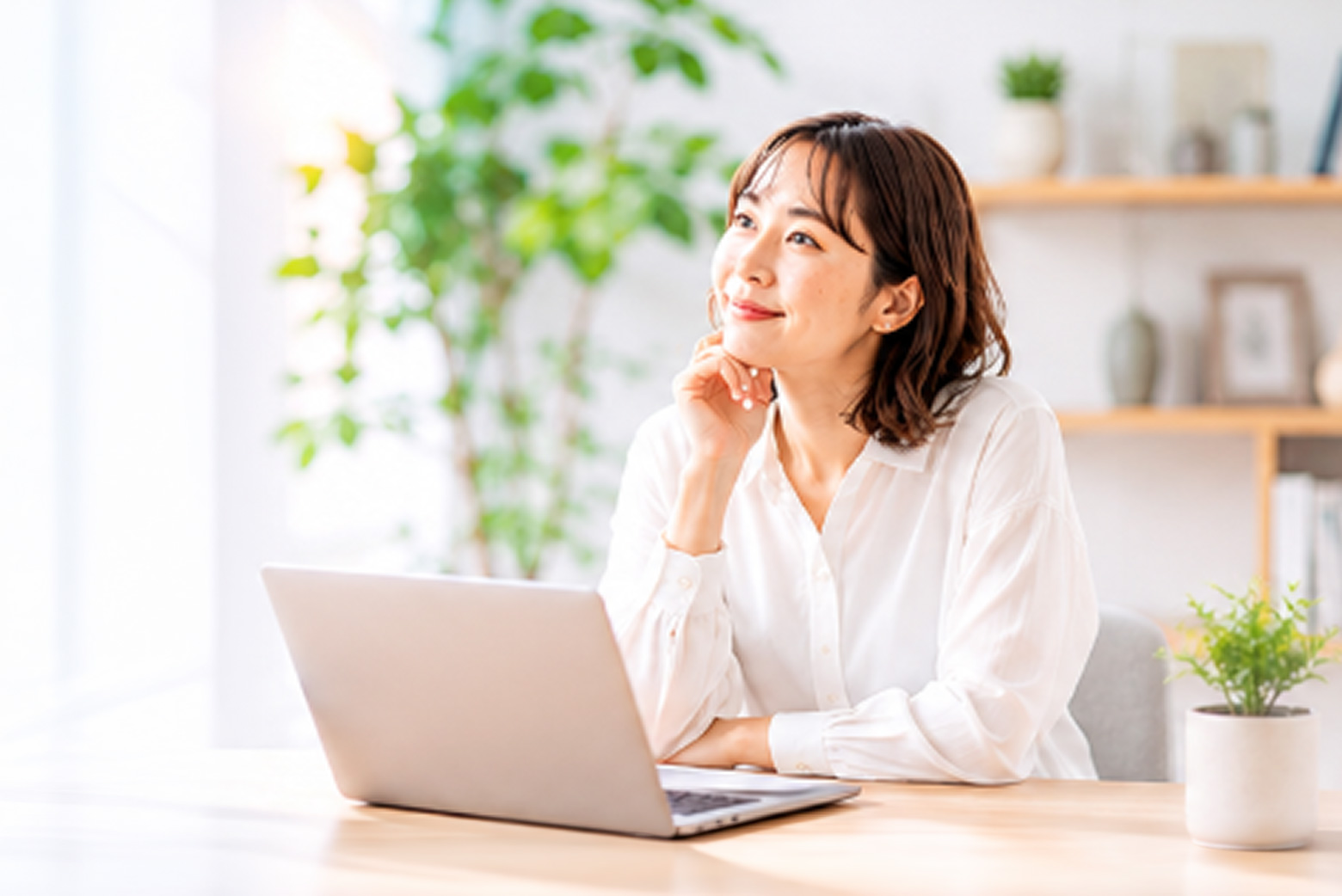 ノートPCの前で考える女性